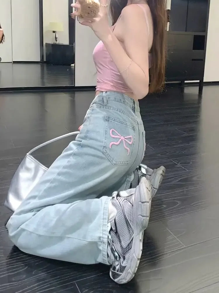 Jeans mit weitem Bein und aufgestickter rosa Schleife