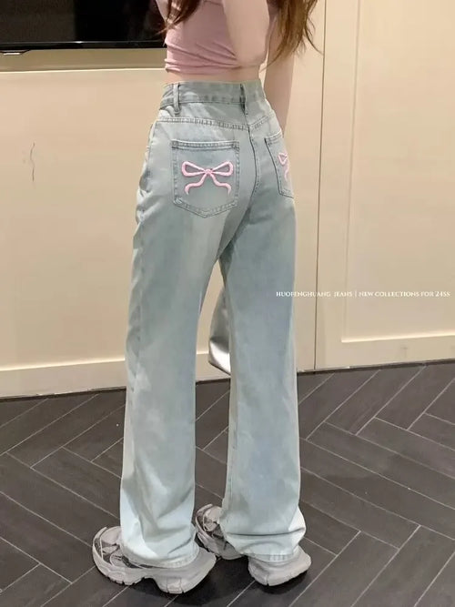 Jeans mit weitem Bein und aufgestickter rosa Schleife